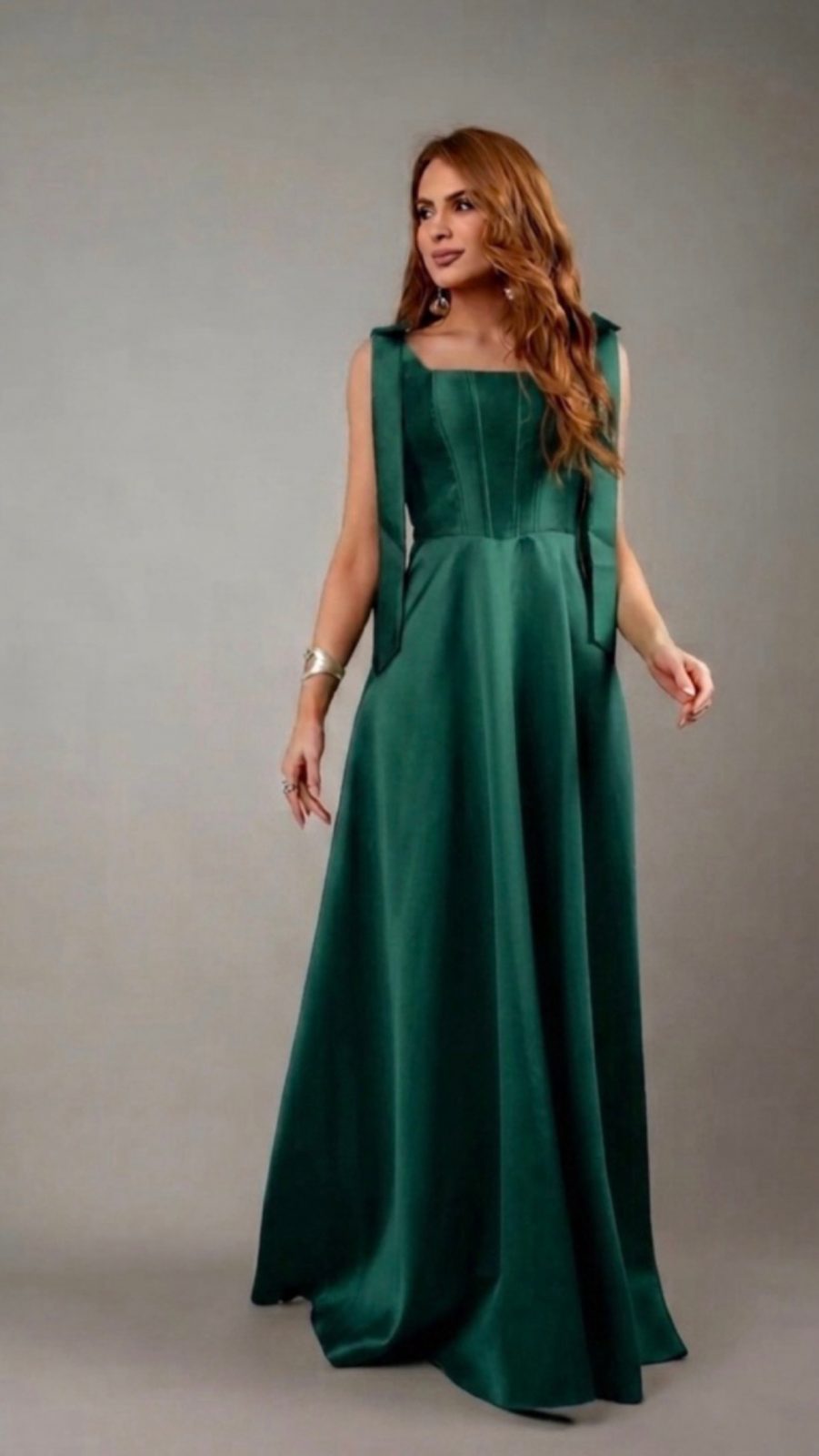 Vestido Longo Verde Esmeralda com Laços nos Ombros  Sofisticado e imponente, este vestido longo em verde esmeralda combina elegância clássica com detalhes modernos. O corpete estruturado com recortes verticais valoriza a silhueta e proporciona u